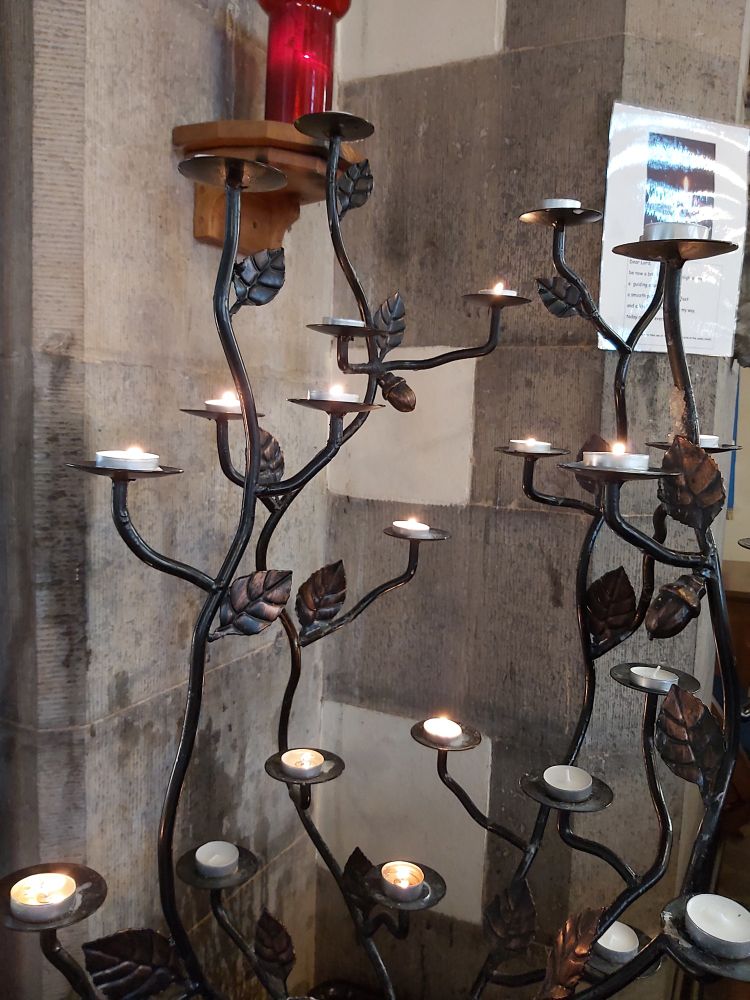 Tealights on a candle stand, lit through the prayers