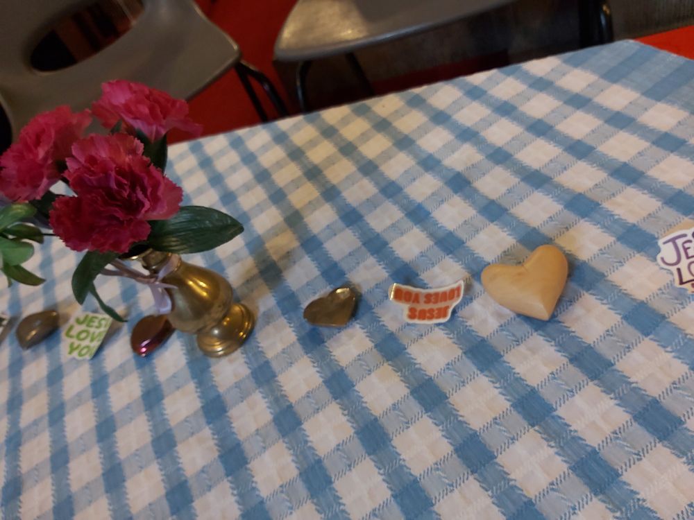 The tables were decorated with stone and wooden hearts, flowers and Jesus loves you stickers