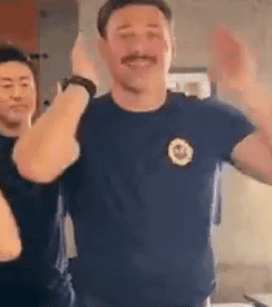 a man with a mustache is dancing with a woman in a blue shirt .