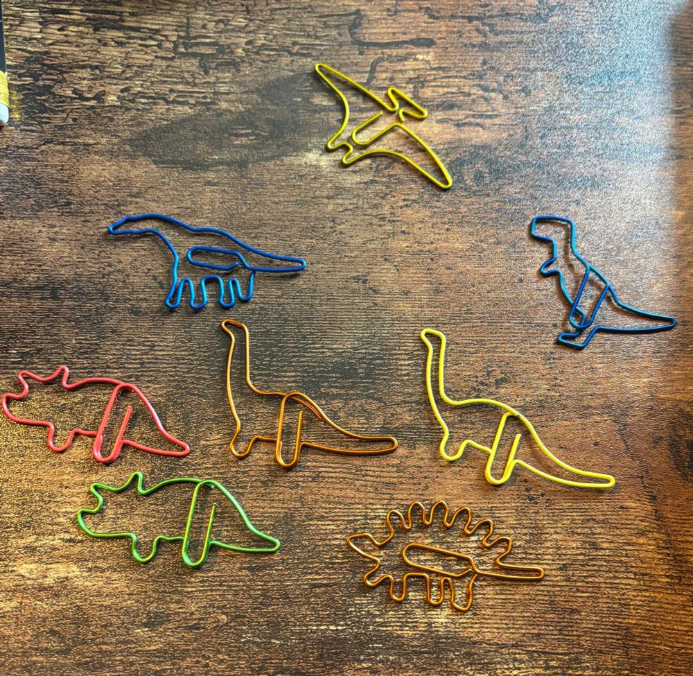 Brightly coloured wire paperclips in dinosaur shapes