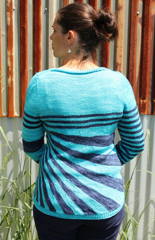 Back of crazy stripes cardigan in front of a striped shed.
