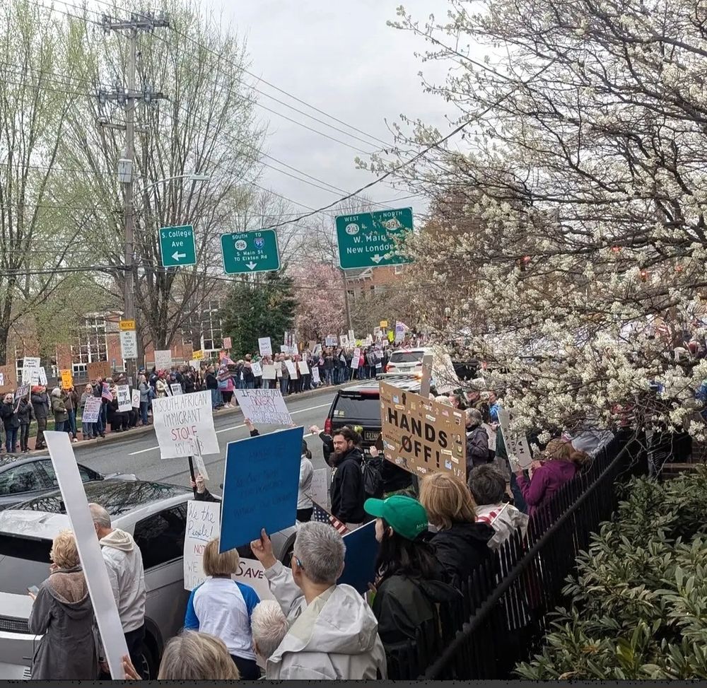 Protestors bearing signs line Main Street of Newark, Delaware, home of UD.