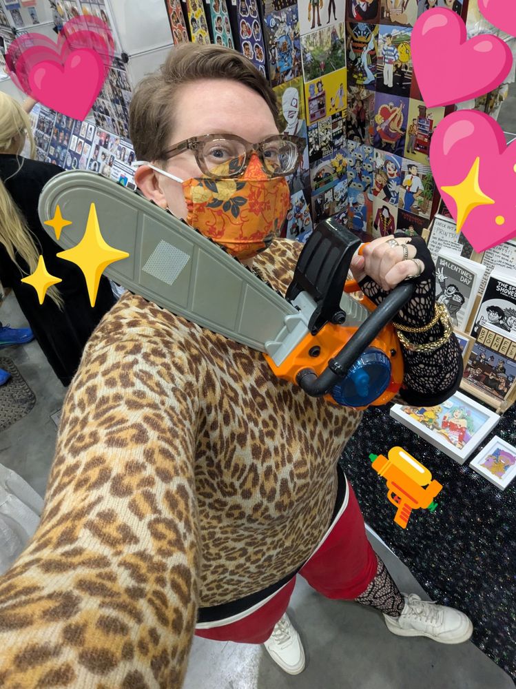 The artist dressed as Akutsu Daimu from Lost Judgment- leopard print sweater on top, red sweatpants below. The artist is posing ultra cute with a prop chainsaw 