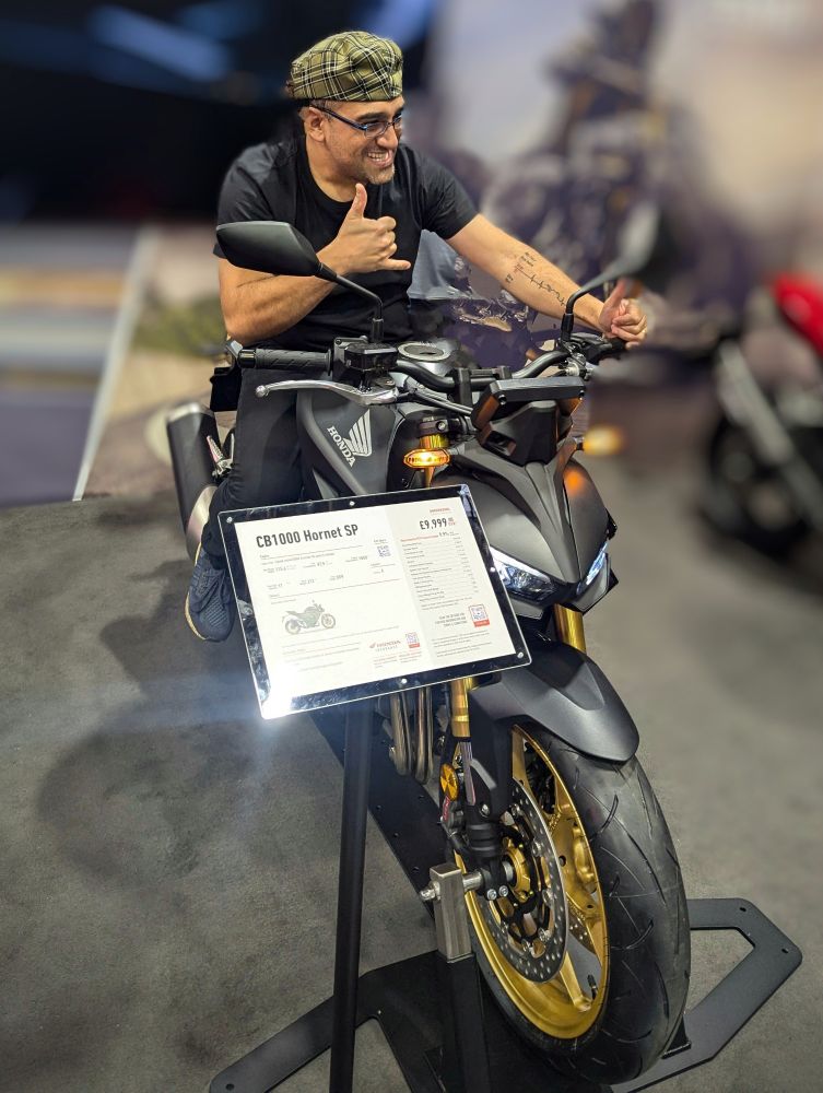 Many on motorcycle. His expression shows the joy of sitting on a new bike.