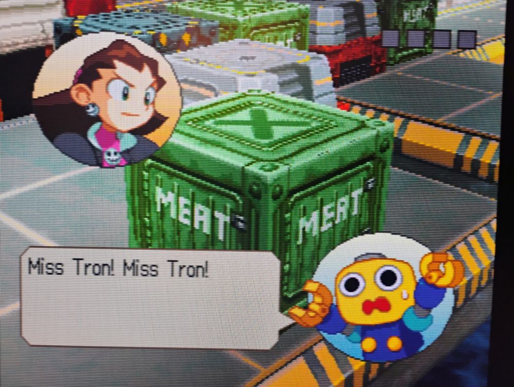 A scene from The Misadventures of Tron Bonne for the Sony PlayStation (PS1 or PSX), featuring a servbot yelling "Miss Tron! Miss Tron!" The background shows a green metal crate labeled "Meat."