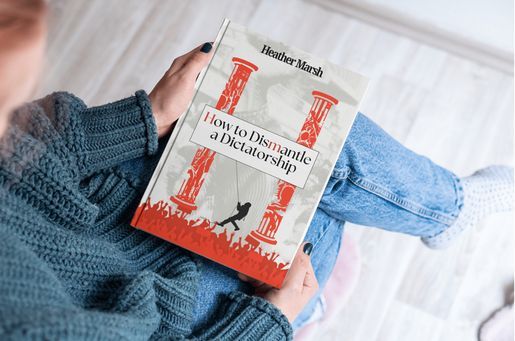 Photo of someone holding Heather Marsh's new book How To Dismantle a Dictatorship in their lap.