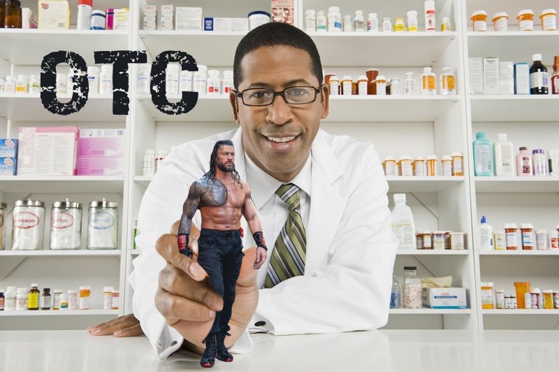 A male pharmacist stands behind a counter, offering you a small Roman Reigns, with the letters OTC in the background in distressed text. 