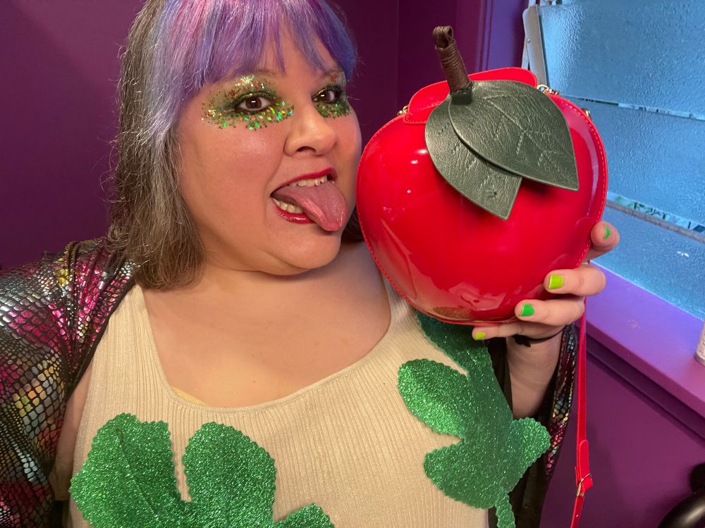 Eve eats the apple with the snake draped around her shoulders 