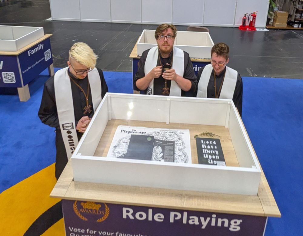 Three priests praying to the public for votes. Lord Have Mercy Upon Is displayed in Hall 4!