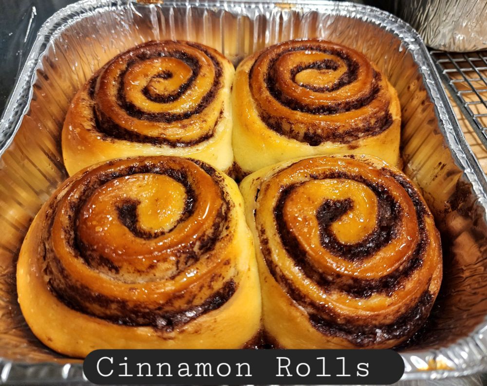 4 large cinnamon rolls in an aluminum pan.