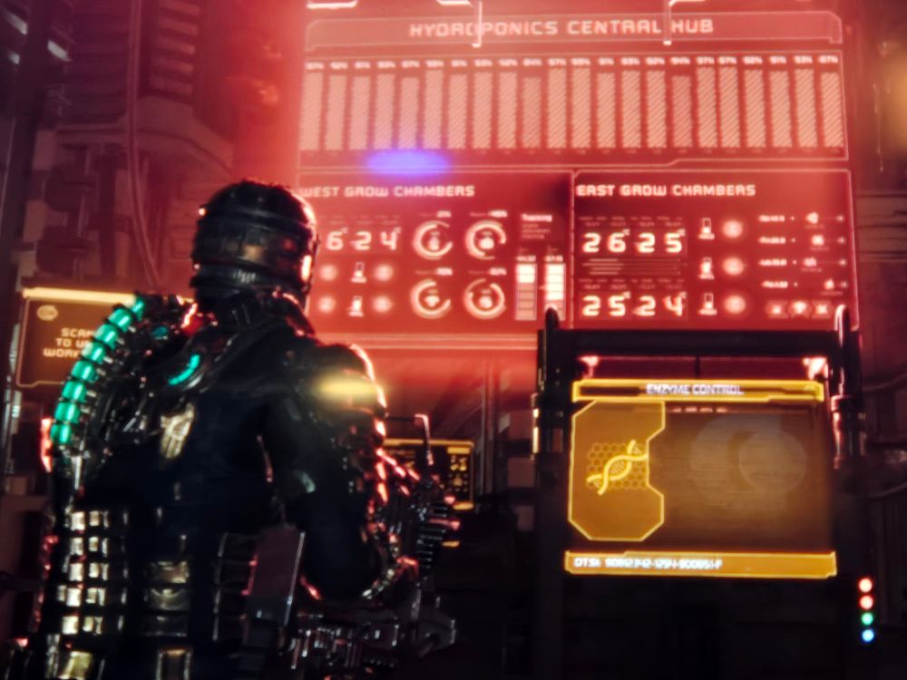 The protagonist of deadspace in an armor suit standing in front of a lit monitor display.