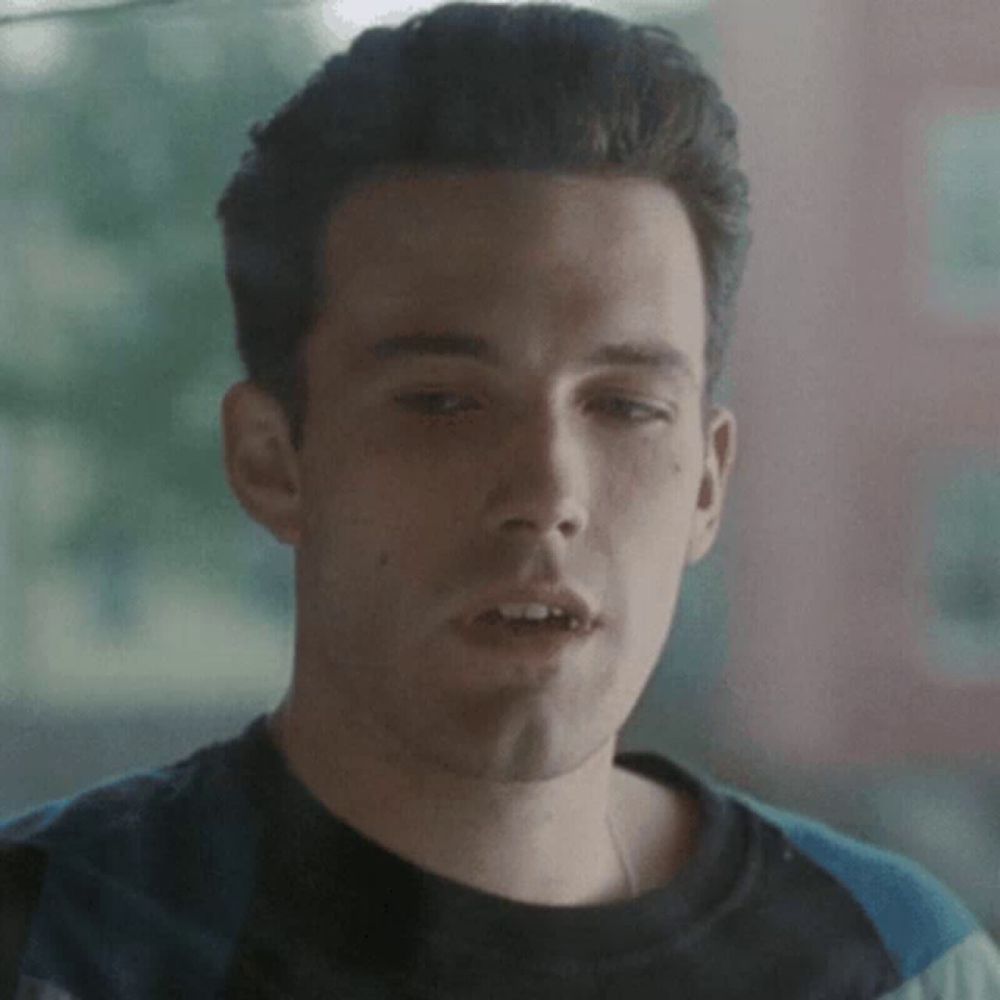 a close up of a man 's face with a striped shirt on