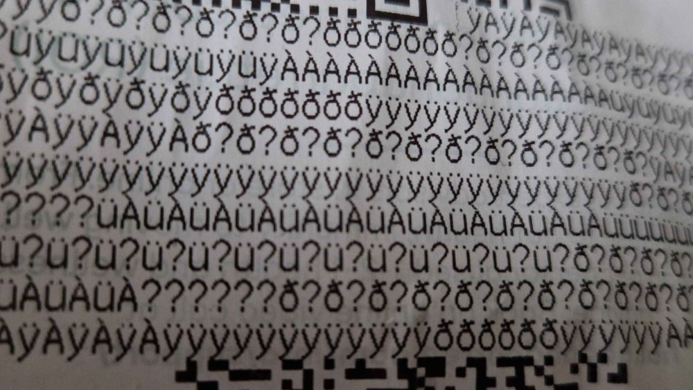 A print out of a receipt trying to print a QR code but instead printing a bunch of symbols.