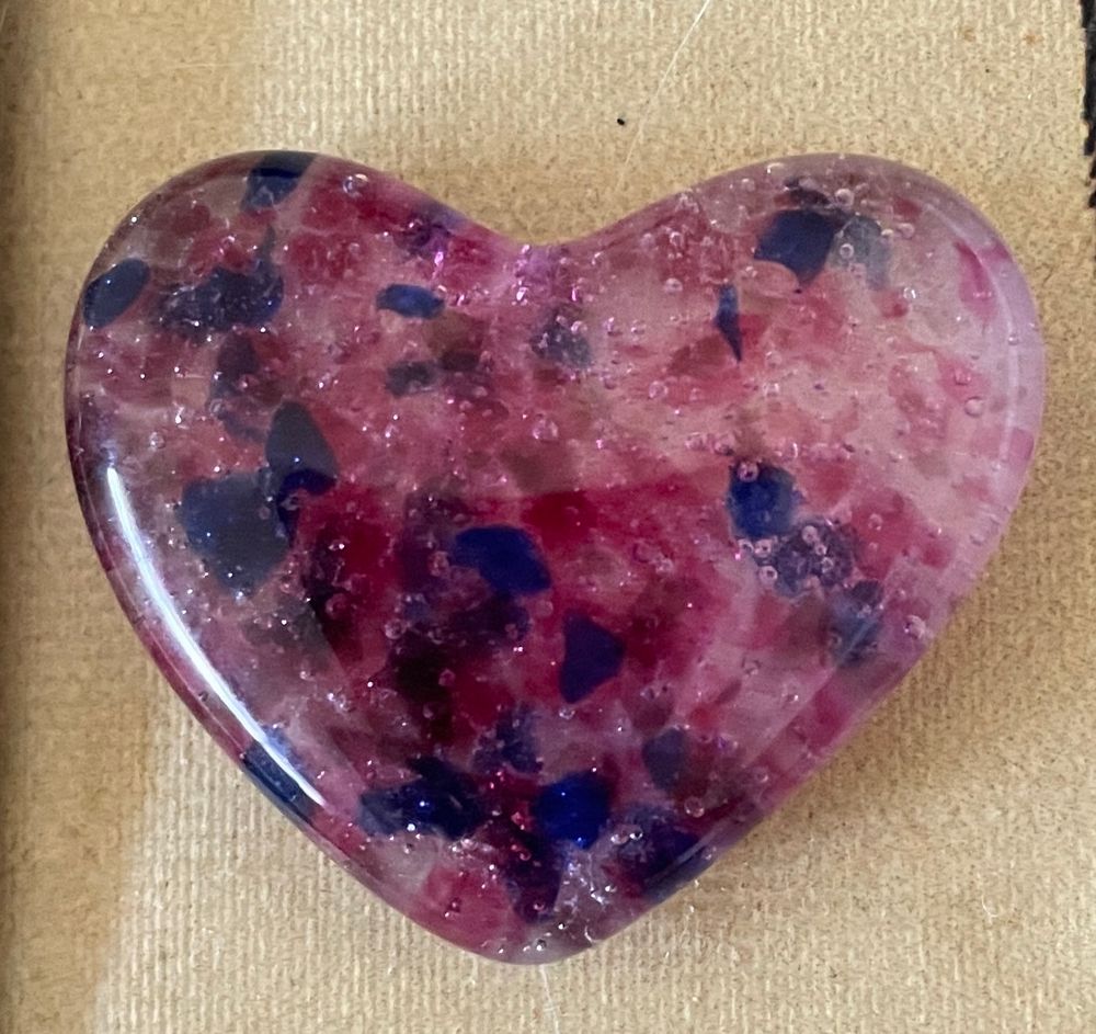 A small glass heart with pink, purple and blue flecks 