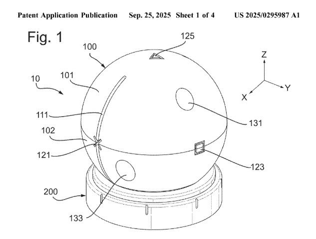 US patent application number 2025/0295987 shows an orb sitting on a base. The orb has a slot down the left side of it and a line across the middle. There's an X logo where the slot and line intersect, a square logo elsewhere along the line, and a triangle logo at the very top. The image is labelled "Fig. 1"