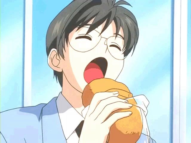 a boy with glasses is eating a sandwich with his mouth wide open