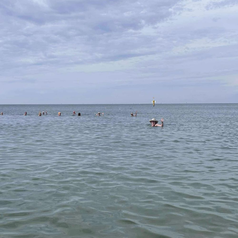 Women’s swimming group swimming out to sea. 