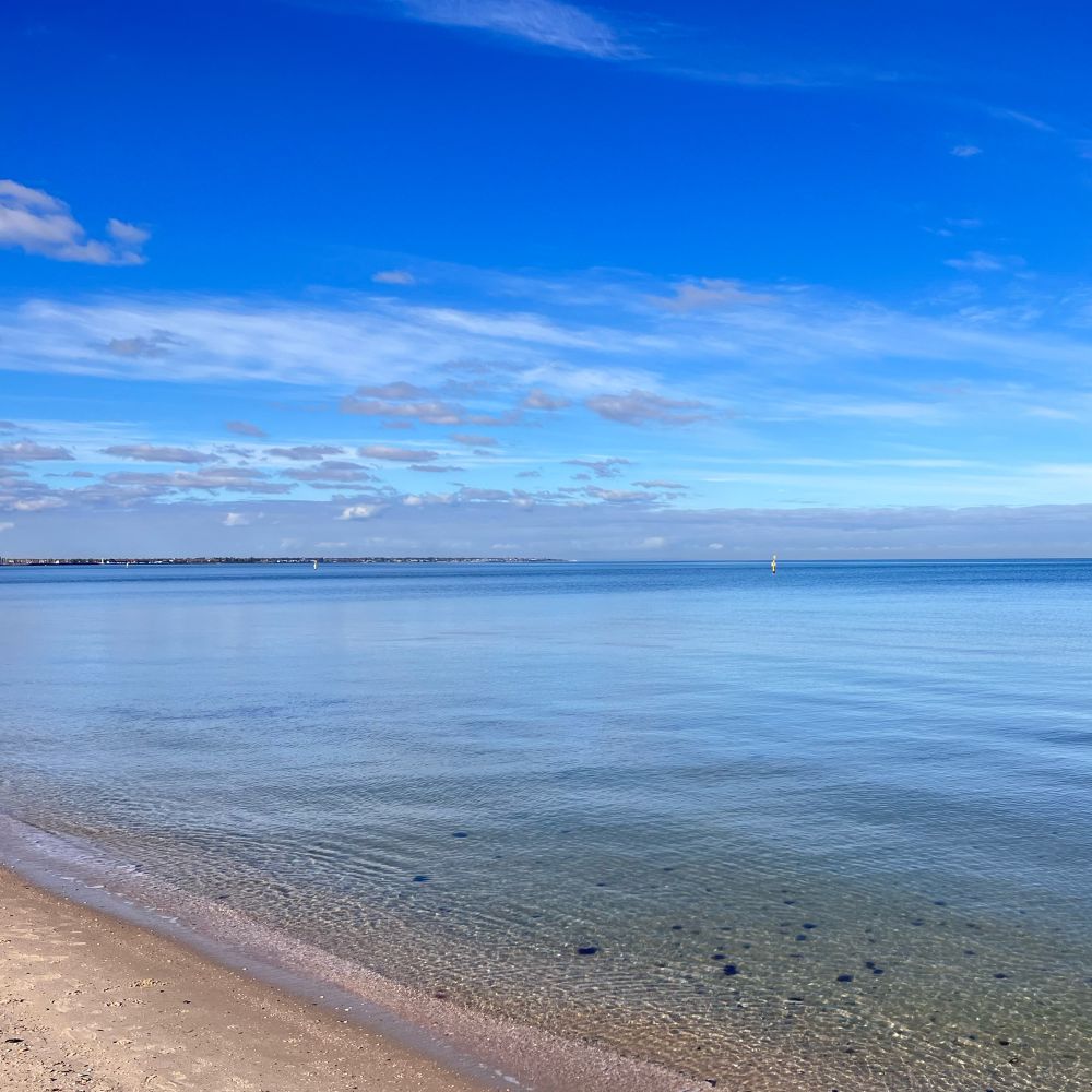 Blue flat clear beach and royal blue skies at Port Melbourne.