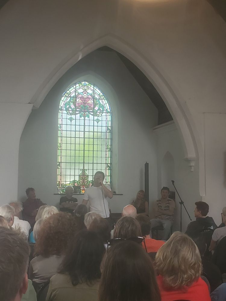 Daniel Galvin speaks into a microphone to an audience at Marino Church.