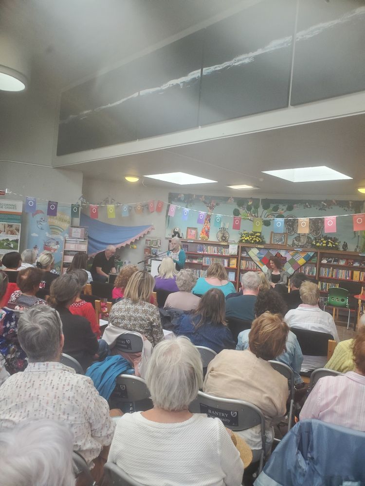 A person reads to an audience in a library