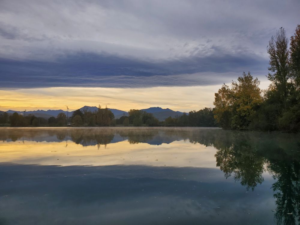 Photo du Mac de Sède au petit matin 
Nuage ciel orangé et arbres se reflètent dans le lac

Comminges 