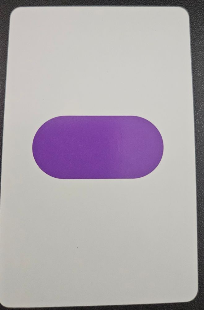 A card from the game Set featuring a filled-in purple oval