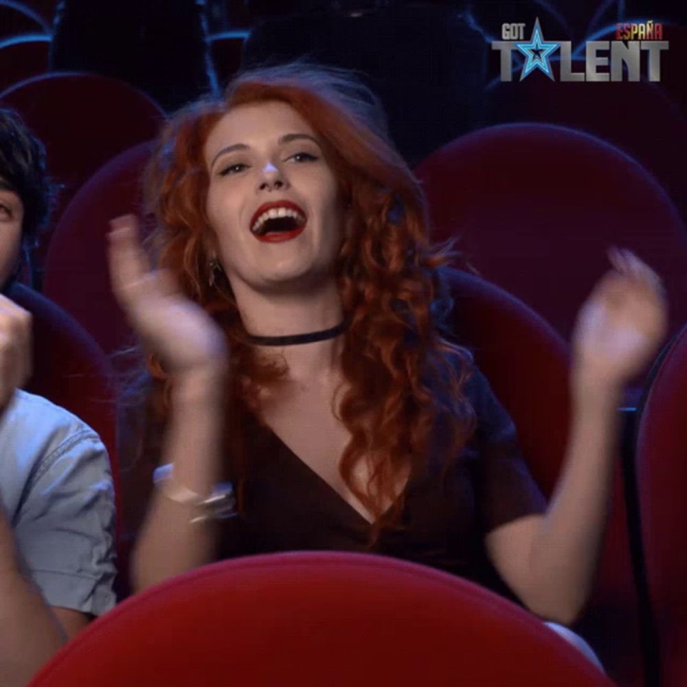 a woman applauds in front of a screen that says espana got talent