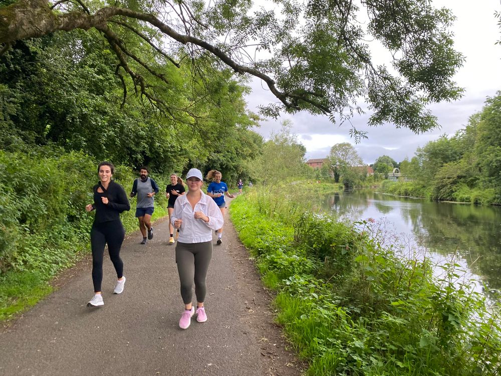 Runners coming towards the camera next to a river