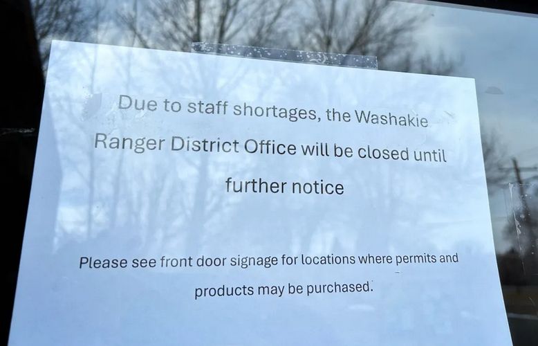 sign on window of ranger office that reads  " sue to staff shortages, the washakie ranger district office will be closed until further notice.  Please see front door signage for locations where permits and products may be purchased.