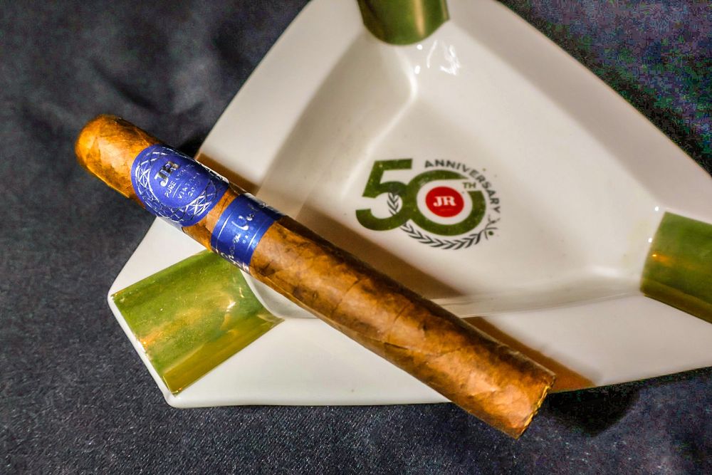 JR Pure Origin Gran Vulcano cigar resting on a JR Cigars 50th Anniversary ash tray.