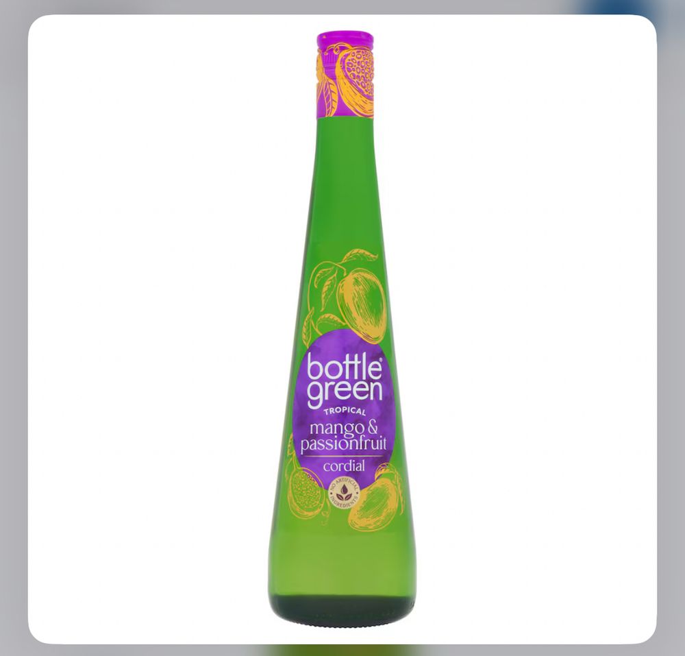 Tall green glass bottle with a pink and yellow lid and a purple sticker saying ‘bottle green mango and passionfruit cordial”. 
