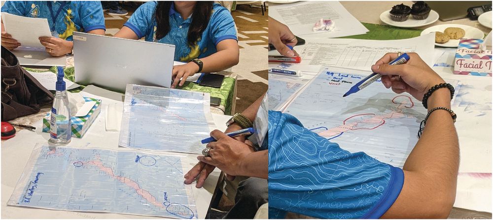 Photograph of workshop participants drawing on basemaps of Palawan using coloured markers and plastic overlays. Photo by Billy Tusker Haworth.