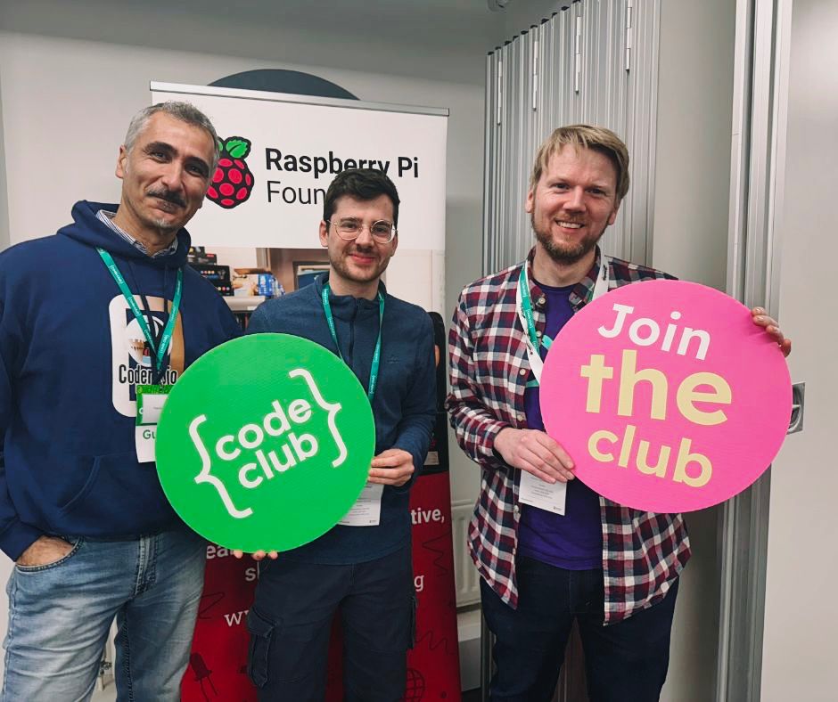A photo of me and other conference attendees holding up code club signs.