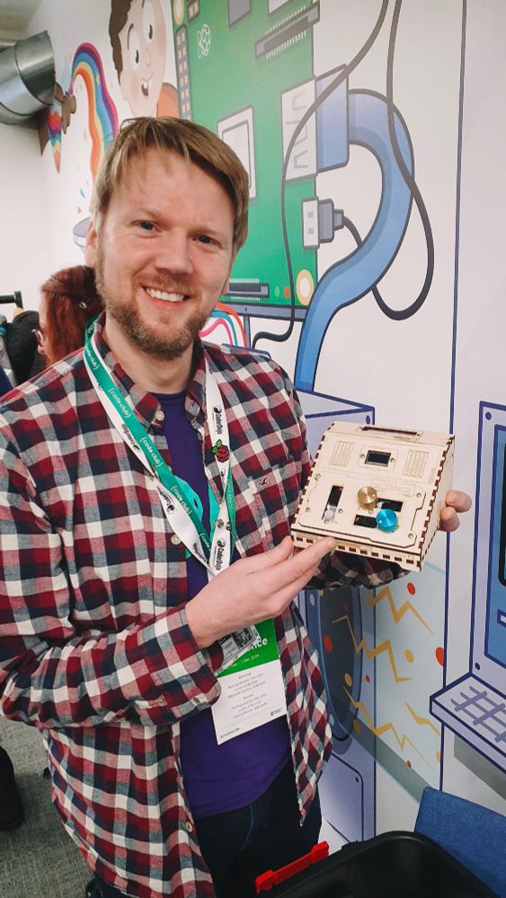 A photo of me holding one of the laser cut wooden boxes, which make up my escape room.