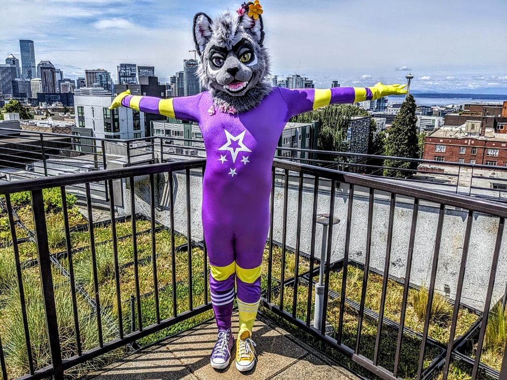 a fursuiter wearing spandex standing on a roof overlooking Seattle. 
