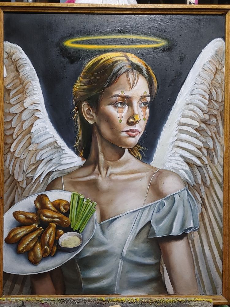 An angel clown with her plate of chicken wings, celery, and dip.