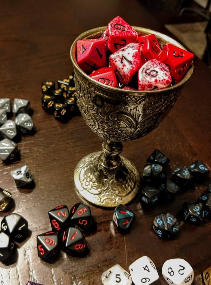 Bloody dice held in a silver chalice on a table.