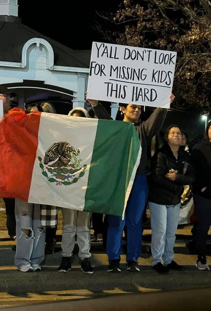 Protestors holding a Mexican flag and a sign that reads "y'all don't look for missing kids this hard."