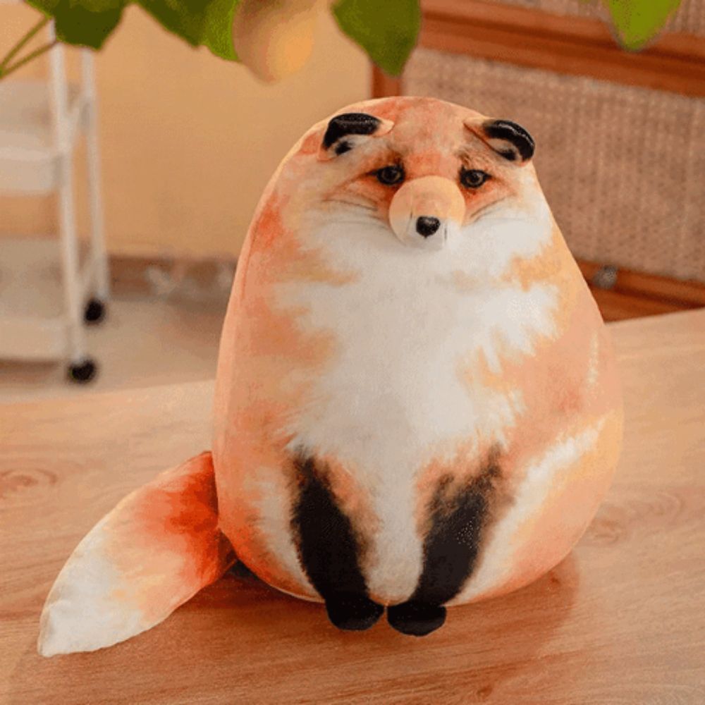 a stuffed animal that looks like a fox sits on a wooden table