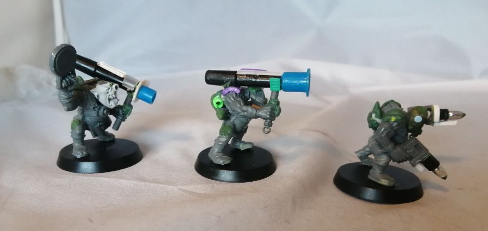 Three ork tankbustas with kitbashed weapons and minor sculpted parts.  Side view.