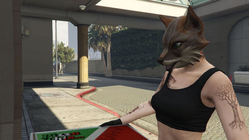 GTAV screenshot of a women with a tree tattoo on her left arm and multiple tattoos on her right arm and the right side of her chest. She is wearing a sports bra with a gray fox mask on and black leather gloves delivering pizza.
