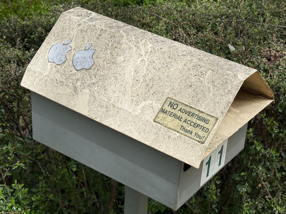 A letterbox showing a sticker saying “No advertising material accepted”, and also has two of the iconic Apple “apple” stickers on it.