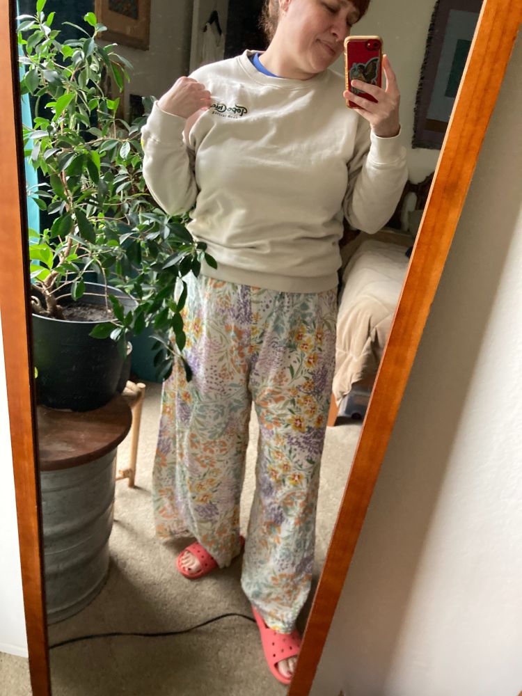 A woman in a pair of high-waisted floral PJ pants with lottttssss of ease. 