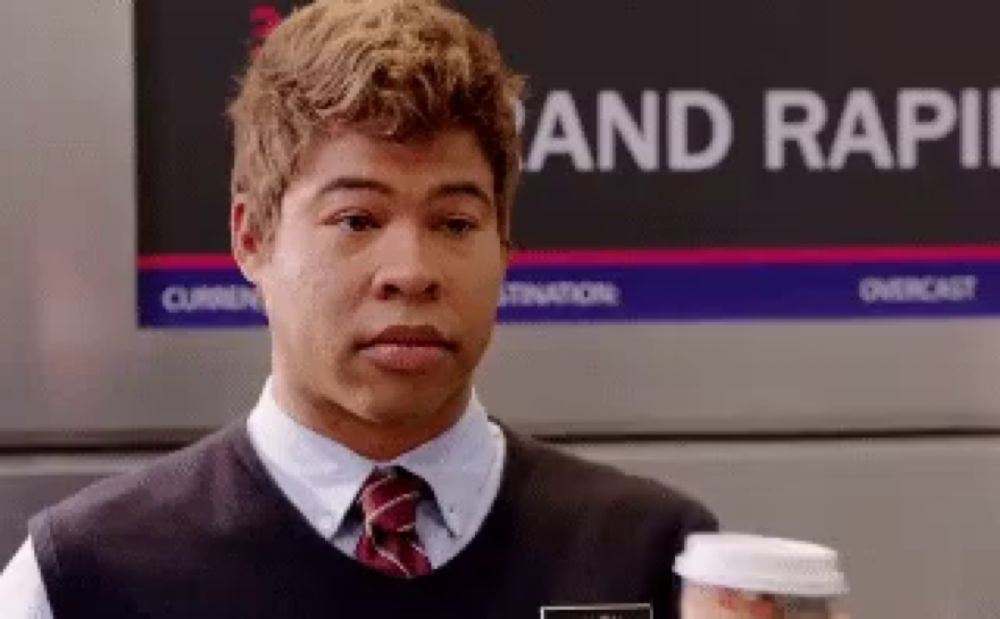 a man holding a cup of coffee in front of a sign that says rapid