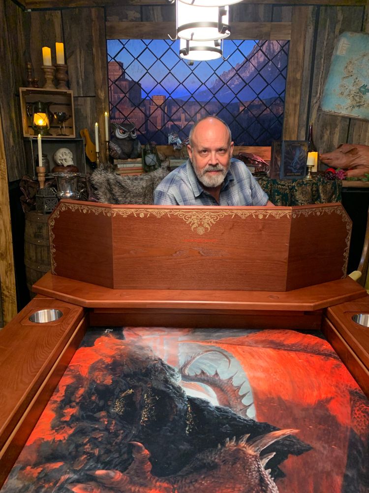 An old man sits at a deluxe D&D table