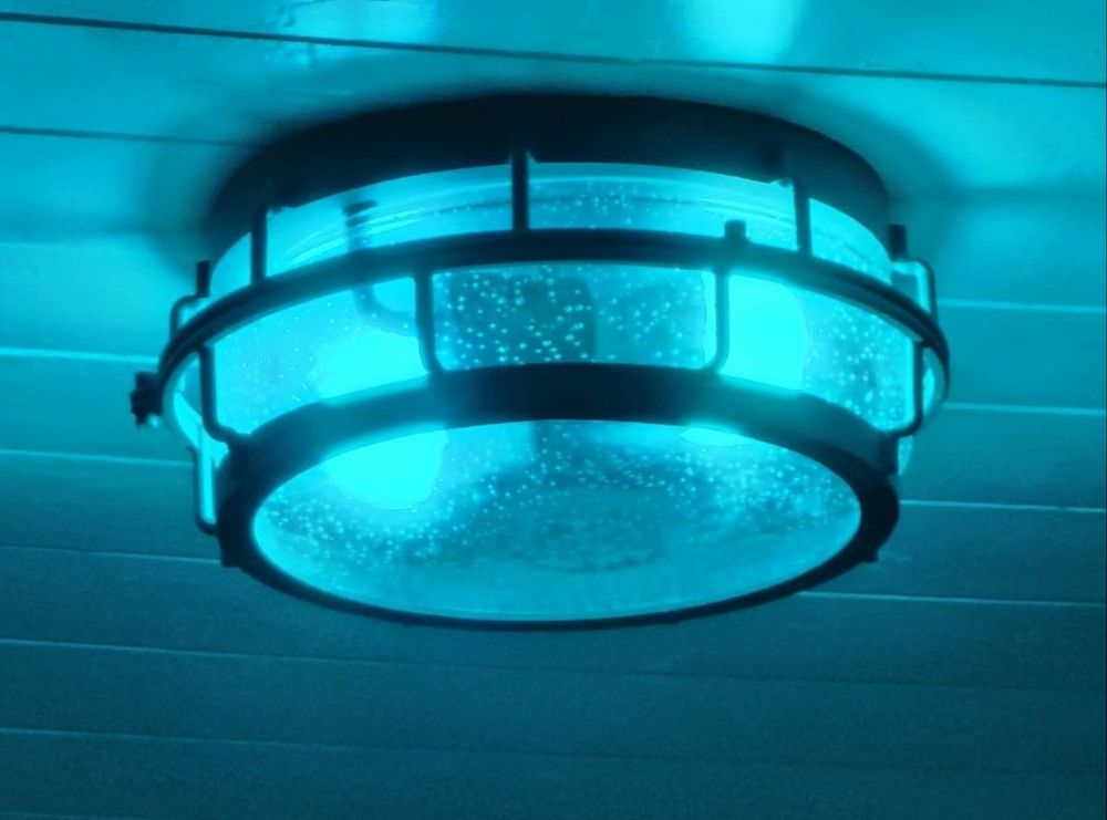 Light fixture shining a teal light for International Long Covid Awareness

