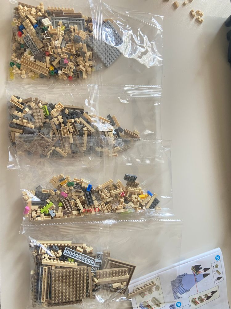 Quatro pacotes fechados com mini peças de Lego 