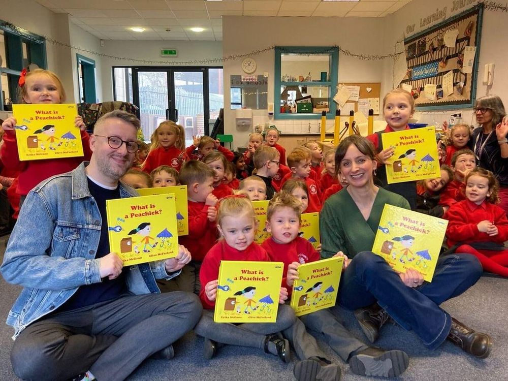 Author and Illustrator of the picture book 'What is a Peachick?' sitting with p2 school group. Each kid holds their own copy of the book.