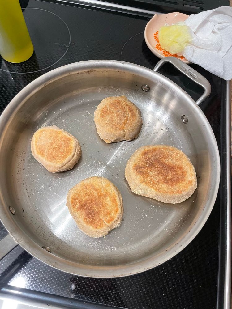 English muffins cooking in a pan