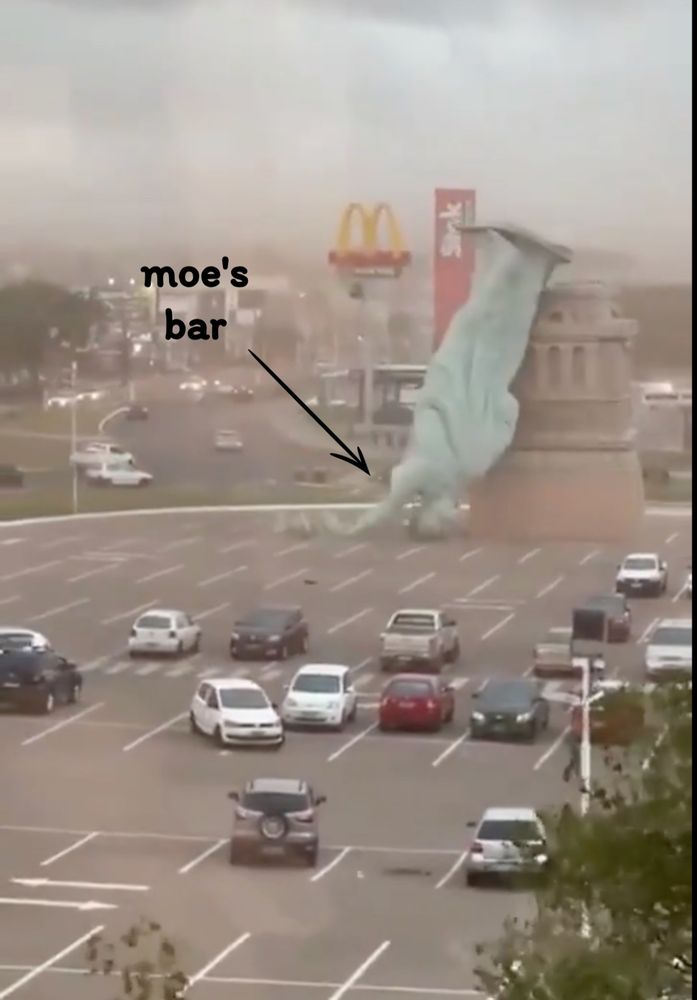 the fallen Brazilian Statue of Liberty with a little arrow pointing to the ground beneath her bulk, and a sign that says "Moe's bar." 